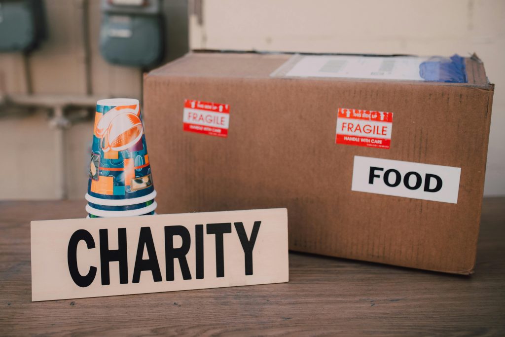 Image of a charity donation box filled with food supplies and paper cups.